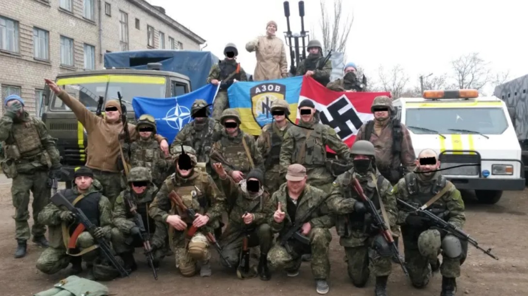 Soldater i Ukraines Azov-bataljon flager med hagekors, NATO’s logo og bataljonens eget flag, mens to soldater heiler. Foto: Heltsumani/CC BY-SA 4.0/Wikimedia Commons