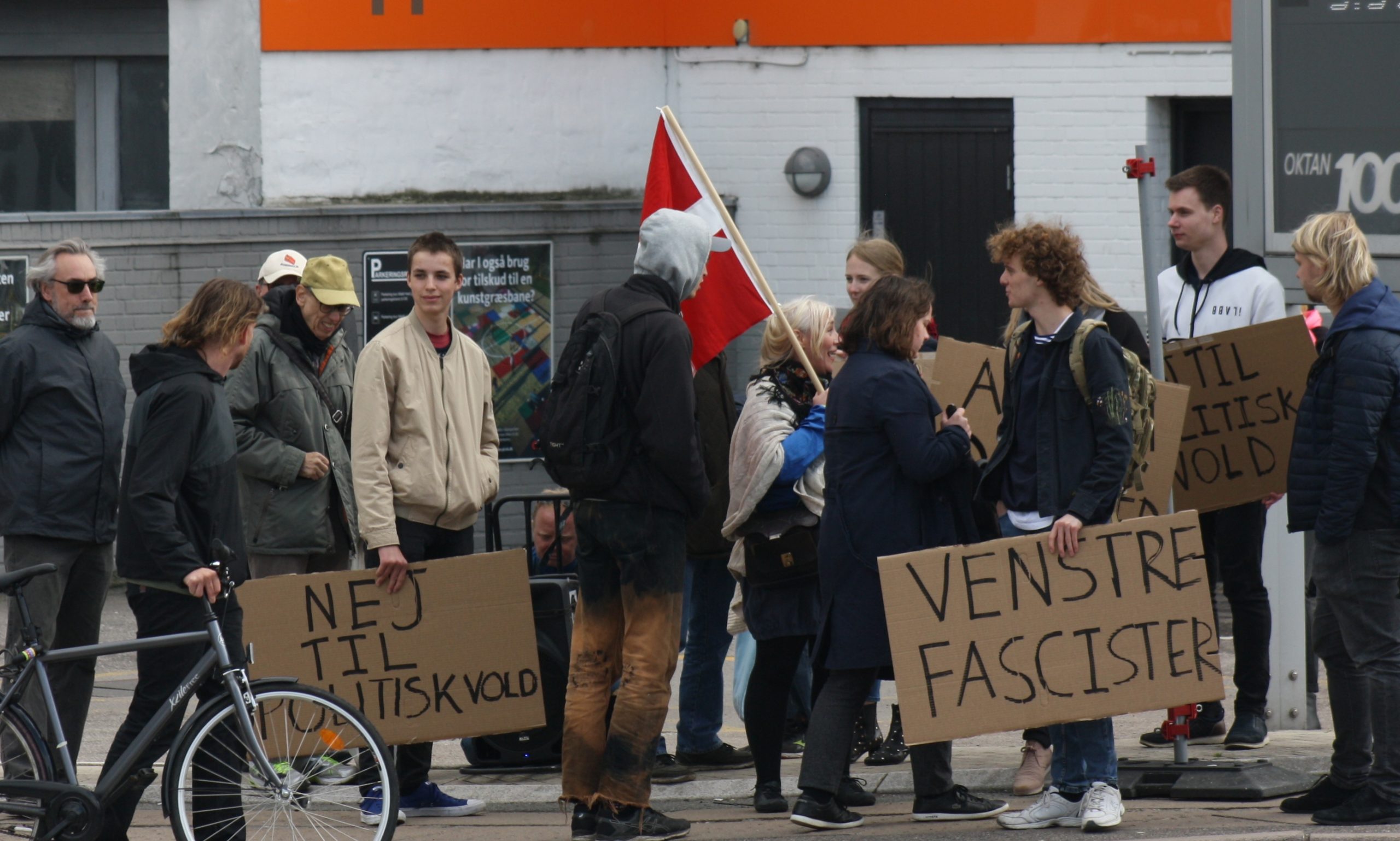 Claes Theilgaard omgivet af folk fra blandt andet For Frihed og Stram Kurs, da han i maj 2019 demonstrede ved Ungdomshuset. Theilgaard står med skiltet, hvor der står 'Venstrefascister'. Foto: Redox